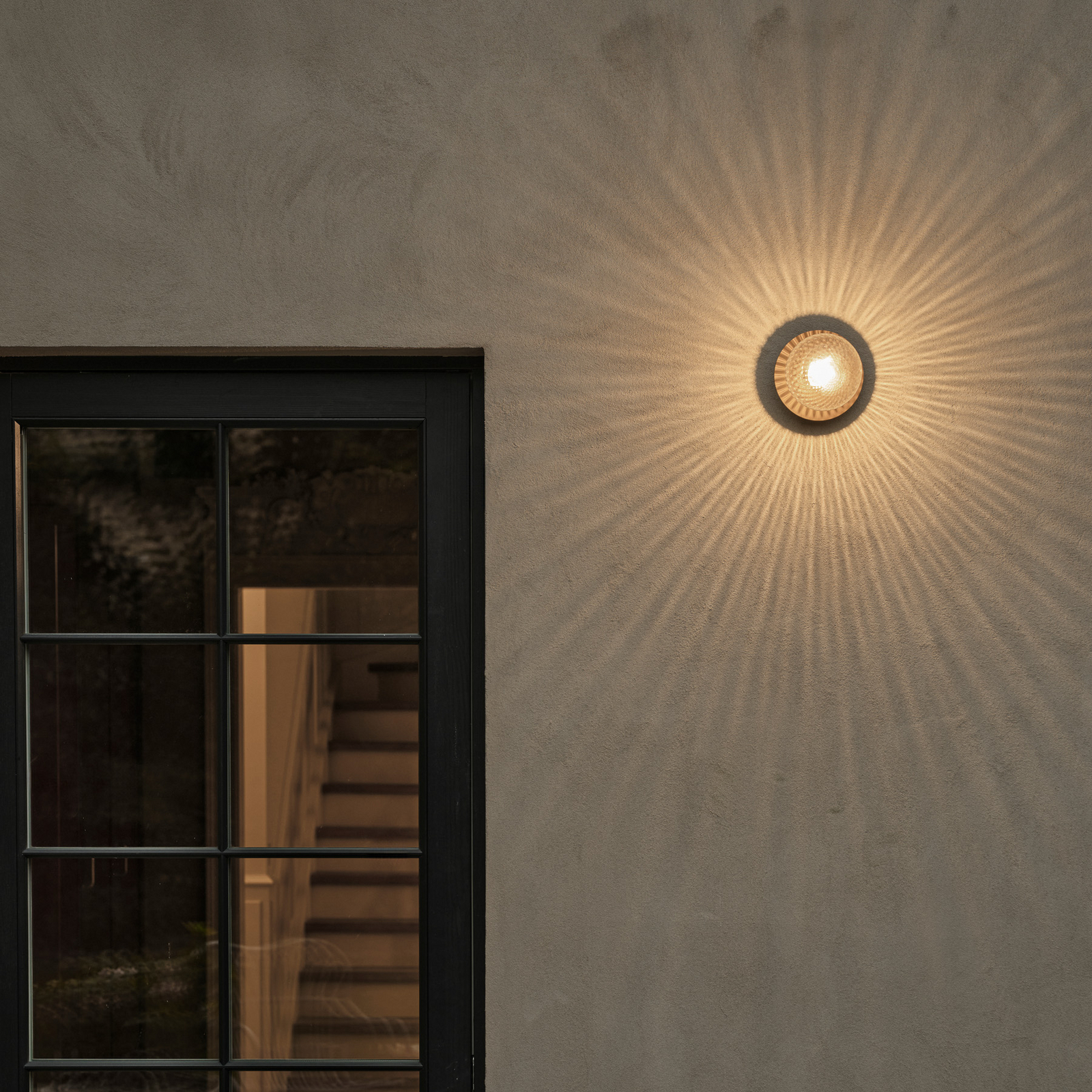 Nuura āra sienas lampa Liila, Ø 16 cm, bronza/caurspīdīga