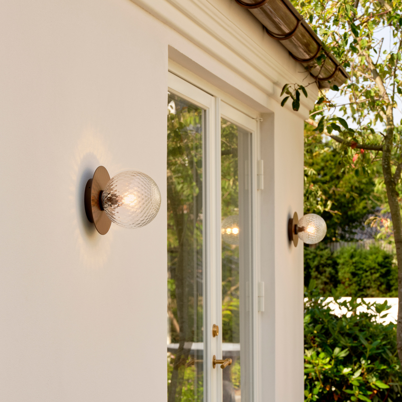 Nuura āra sienas lampa Liila, Ø 16 cm, bronza/caurspīdīga